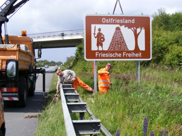 Montage des Schildes "Ostfriesland - Friesische Freiheit" an der Autobahn